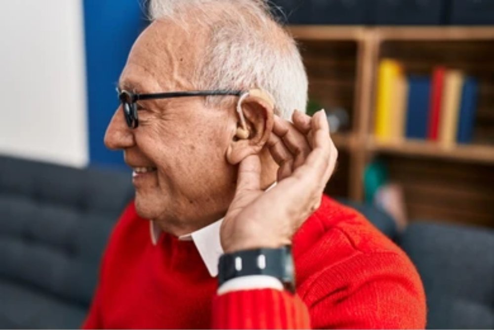 Happy senior wearing hearing aid enjoying conversation at home